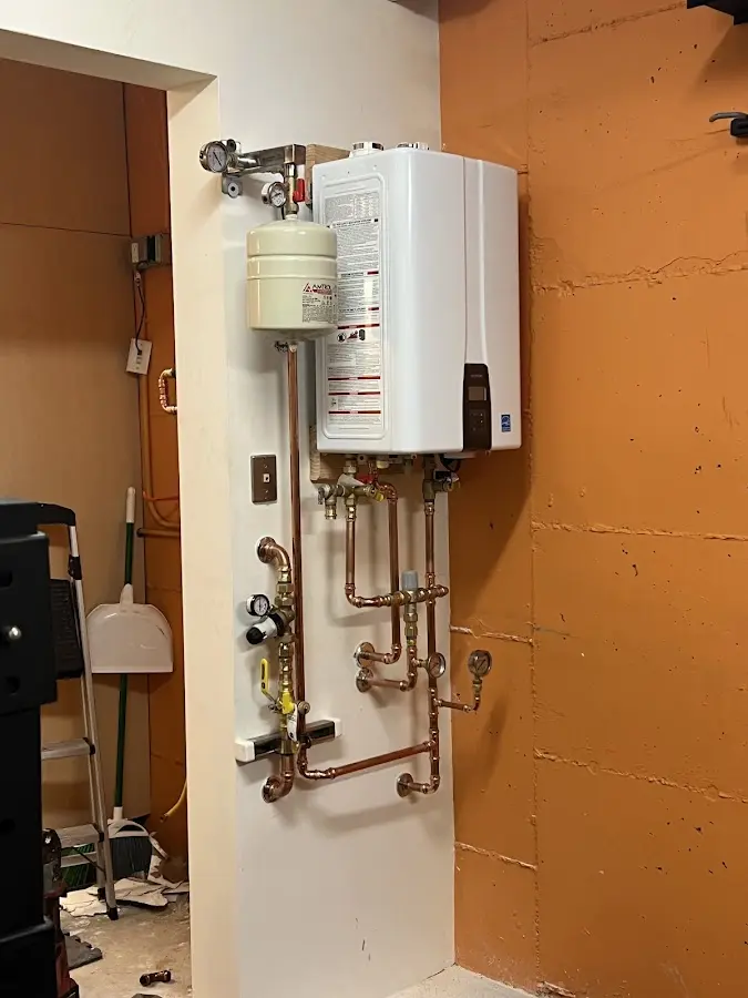 Plumbing technician inspecting water heater connections in Meadows Place